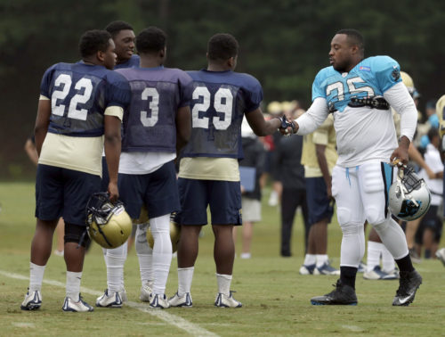 Carolina Panthers' Mike Tolbert, right, greets members of the Spartanburg High School football team during an NFL training camp practice in Spartanburg, S.C., Thursday, Aug. 4, 2016. The high school participated in pre-practice stretching with the Panthers and held their own practice on an adjacent field. (AP Photo/Chuck Burton)