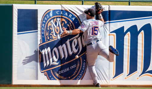 Oct 11, 2016; Glendale, AZ, USA; Scottsdale Scorpions outfielder Tim Tebow of the New York Mets crashes into the outfield wall as he attempts to catch a fly ball during the fifth inning against the Glendale Desert Dogs during an Arizona Fall League game at Camelback Ranch. Mandatory Credit: Mark J. Rebilas-USA TODAY Sports