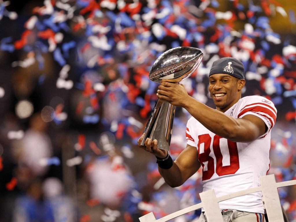 Feb 5, 2012; Indianapolis, IN, USA; New York Giants wide receiver Victor Cruz (80) hoists the Vince Lombardi Trophy after Super Bowl XLVI against the New England Patriots at Lucas Oil Stadium. Mandatory Credit: Andrew Mills/THE STAR-LEDGER via US PRESSWIRE