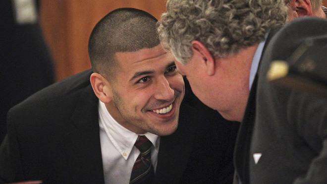 Former New England Patriots player Aaron Hernandez (L) smiles at his defense attorney Michael Fee as he appears in court at the Fall River Justice Center in Fall River, Massachusetts December 23, 2013. The former NFL tight end is charged in the fatal shooting of his friend, Odin Lloyd, in June 2013. REUTERS/Matt Stone/Pool (UNITED STATES - Tags: CRIME LAW SPORT FOOTBALL) - RTX16SPU